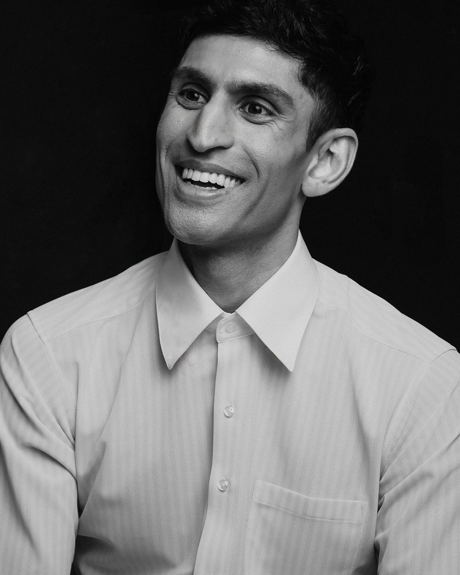 Black-and-white photo of Rounak Zoeb laughing, looking off to the side.