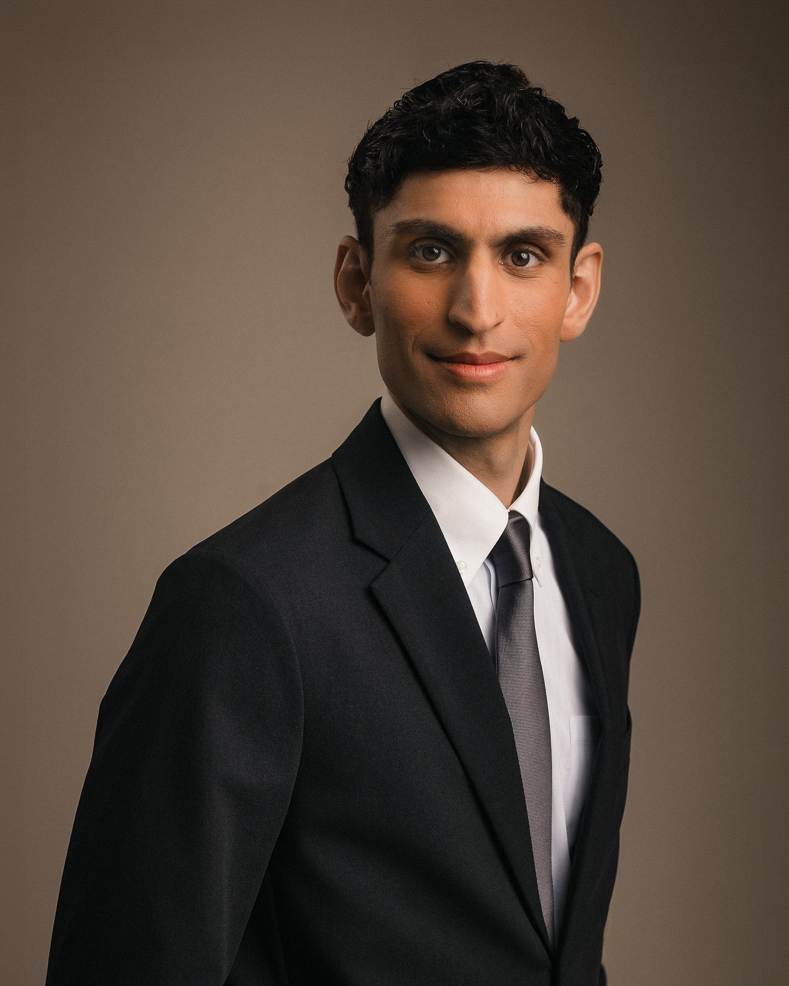 Rounak Zoeb in a dark suit and grey tie.